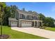 Stately two-story home with a three-car garage, long driveway, and inviting front porch with seating at 165 Hickory Grv Dr, Sanford, NC 27330