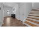 Bright hallway with wood floors, stairs, and a view of the front door and foyer at 165 Hickory Grv Dr, Sanford, NC 27330