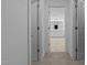Hallway featuring an open view of the bright, clean, white bathroom and tile flooring at 165 Hickory Grv Dr, Sanford, NC 27330