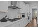 Modern kitchen features white cabinets, a stainless steel range hood, and a gas cooktop at 165 Hickory Grv Dr, Sanford, NC 27330