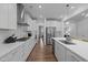 A well-lit kitchen featuring a central island, white cabinets, stainless steel appliances, and hardwood floors at 165 Hickory Grv Dr, Sanford, NC 27330