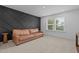 Finished living room with accent wall, neutral carpet, and large bright window at 165 Hickory Grv Dr, Sanford, NC 27330