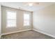A bright bedroom with neutral walls, soft carpet, and natural light coming through two windows at 165 Sutherland Dr, Franklinton, NC 27525