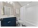 Bathroom with blue vanity, sink, and tub-shower combo with white subway tile at 1809 Bowling Rd, Fuquay Varina, NC 27526