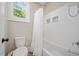 Cozy bathroom featuring a shower-tub combo with white subway tile and a window at 1809 Bowling Rd, Fuquay Varina, NC 27526