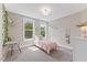 Neutral bedroom featuring two windows, a bed, desk, and white dresser at 1809 Bowling Rd, Fuquay Varina, NC 27526