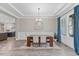 Dining room featuring natural light from large windows, hardwood floors, and modern chandelier at 1809 Bowling Rd, Fuquay Varina, NC 27526
