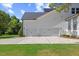 Exterior garage view with a three-car capacity, surrounded by a green lawn and landscaping at 1809 Bowling Rd, Fuquay Varina, NC 27526