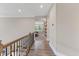 Hallway with wood floors, wood and iron railing, and built-in shelving in a bonus room at 1809 Bowling Rd, Fuquay Varina, NC 27526