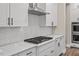 Modern kitchen featuring white cabinetry, herringbone backsplash, quartz countertops, and stainless steel appliances at 1809 Bowling Rd, Fuquay Varina, NC 27526