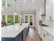 Bright and open kitchen boasts a large island, modern appliances, white cabinets, and backyard views at 1809 Bowling Rd, Fuquay Varina, NC 27526