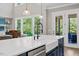 Bright kitchen with a large island, farmhouse sink, stainless steel appliances and an open view to the backyard at 1809 Bowling Rd, Fuquay Varina, NC 27526