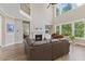 Bright living room featuring a fireplace, piano, hardwood floors, and a large window with natural light at 1809 Bowling Rd, Fuquay Varina, NC 27526