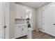 Mudroom featuring white cabinetry, countertops, adjacent to a hallway and office area with hardwood floors at 1809 Bowling Rd, Fuquay Varina, NC 27526