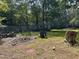 Exterior of a home and overgrown backyard with debris and mature trees at 194 John Mitchell Rd, Youngsville, NC 27596