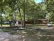 Exterior of a home with a circle drive and multiple buildings surrounded by trees at 194 John Mitchell Rd, Youngsville, NC 27596