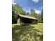 Charming log cabin with a metal roof and inviting front porch surrounded by trees at 2011 Bowmantown Rd, Roxboro, NC 27574