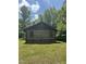 Charming log cabin featuring a metal roof nestled among lush green trees at 2011 Bowmantown Rd, Roxboro, NC 27574
