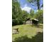Log cabin exterior with a metal roof, surrounded by a lush green lawn and trees at 2011 Bowmantown Rd, Roxboro, NC 27574