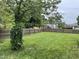 Expansive, fully fenced backyard with lush green grass and mature trees, perfect for outdoor activities at 205 Woodhaven Dr, Burlington, NC 27217