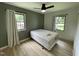 Bedroom featuring hardwood floors, modern fan and light green accent wall at 205 Woodhaven Dr, Burlington, NC 27217
