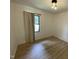 Empty bedroom featuring light hardwood floors, overhead lighting, and a black-framed window at 205 Woodhaven Dr, Burlington, NC 27217