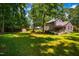 Expansive backyard featuring a well-maintained lawn, outbuilding, deck with seating, and lush greenery at 206 Lisa Dr, Carrboro, NC 27510