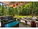 Relaxing covered deck with comfortable seating, string lights, and views of the lush, green backyard at 206 Lisa Dr, Carrboro, NC 27510