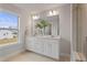Bathroom features double vanity with quartz countertop, large mirror, and window with outside view at 21 Whistling Way # 17, Lillington, NC 27546