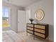 This light bedroom includes a modern dresser with wood elements and a stylish round mirror above at 21 Whistling Way # 17, Lillington, NC 27546