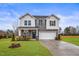 Charming two-story home with gray and white siding, a two-car garage, and a manicured lawn at 21 Whistling Way # 17, Lillington, NC 27546