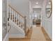 Inviting foyer with light wood floors, stairwell, and an open view into the living room at 21 Whistling Way # 17, Lillington, NC 27546