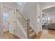 Hallway with carpeted stairs, wood flooring, white trim, and a view into the living room at 21 Whistling Way # 17, Lillington, NC 27546