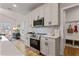 Kitchen featuring white cabinets, stainless steel appliances, mosaic tile backsplash, and wood-look floors at 21 Whistling Way # 17, Lillington, NC 27546