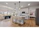 Open kitchen features white cabinets, an island with seating, modern pendant lighting, and seamless flow to the dining area at 21 Whistling Way # 17, Lillington, NC 27546