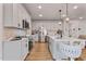 Bright kitchen features white cabinetry, stainless steel appliances, and a large island with pendant lighting at 21 Whistling Way # 17, Lillington, NC 27546
