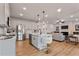 Open concept kitchen with stainless appliances, pendant lights, island seating, and a seamless view into the living area at 21 Whistling Way # 17, Lillington, NC 27546