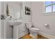 Stylish powder room featuring a pedestal sink, sleek toilet, and modern wall decor at 21 Whistling Way # 17, Lillington, NC 27546