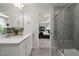This bathroom features double sinks, white cabinets, and a tiled walk-in shower with a bench at 2301 Edenberry Ln, Fuquay Varina, NC 27526