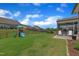 Expansive backyard features a black metal fence, playset and covered patio with seating at 2626 Nassau Trce, Fuquay Varina, NC 27526