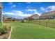 Spacious fenced backyard featuring green grass, a playground, and plenty of room for outdoor activities at 2626 Nassau Trce, Fuquay Varina, NC 27526