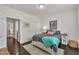 Bedroom with dark wood floors, neutral paint, and access to the hallway at 2626 Nassau Trce, Fuquay Varina, NC 27526