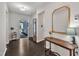 Inviting foyer with dark hardwood floors, decorative mirror, and a view of the front door at 2626 Nassau Trce, Fuquay Varina, NC 27526
