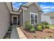Close-up of the front entrance showcasing a landscaped walkway, window and lovely gray vinyl siding at 2626 Nassau Trce, Fuquay Varina, NC 27526