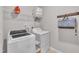 Bright laundry room with modern appliances, overhead shelving, and ample space for sorting and folding at 2626 Nassau Trce, Fuquay Varina, NC 27526