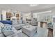 Open-concept living room with plush seating, wood floors, and a view of the kitchen and dining area at 2626 Nassau Trce, Fuquay Varina, NC 27526