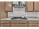 Close-up of the cooktop featuring stainless steel appliances, granite countertops, and white subway tile backsplash at 2626 Nassau Trce, Fuquay Varina, NC 27526