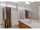 Cozy bathroom featuring a combined shower-tub, wooden vanity, and a neutral-colored shower curtain at 2941 Grandview Heights Lane Ln, Raleigh, NC 27614