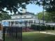 Beautiful clubhouse with a covered patio and view of the manicured green lawn area and blue umbrellas at 2941 Grandview Heights Lane Ln, Raleigh, NC 27614