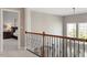 Upstairs hallway with spindled railing overlooking a bedroom with natural light and neutral decor at 2941 Grandview Heights Lane Ln, Raleigh, NC 27614